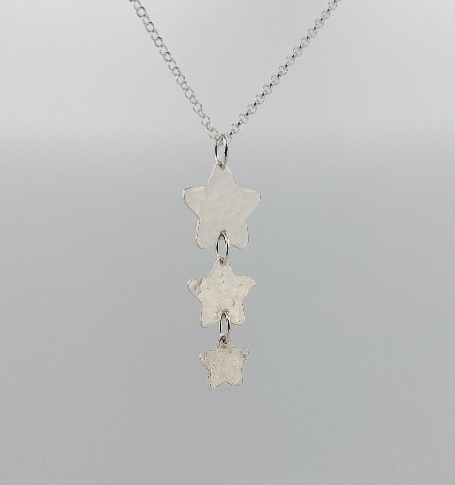 Silver star-shaped pendant necklace on a gray background