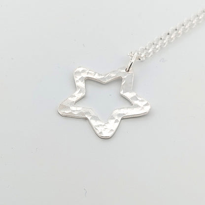 Silver star-shaped pendant on a light gray background