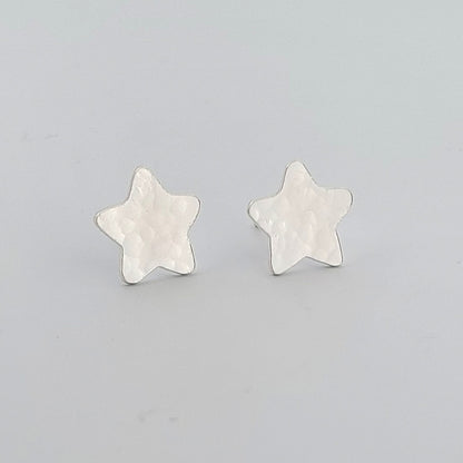 Star-shaped silver earrings on a light gray background