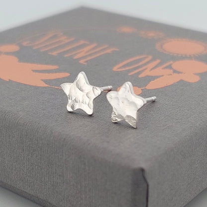 Silver star-shaped earrings on a Shine On gift box